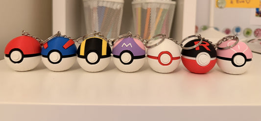 All seven 3D printed Pokéball fidget clicker keychains lined up