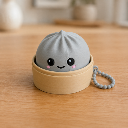 Ash Gray dumpling fidget clicker keychain in its bamboo steamer basket, with ball chain