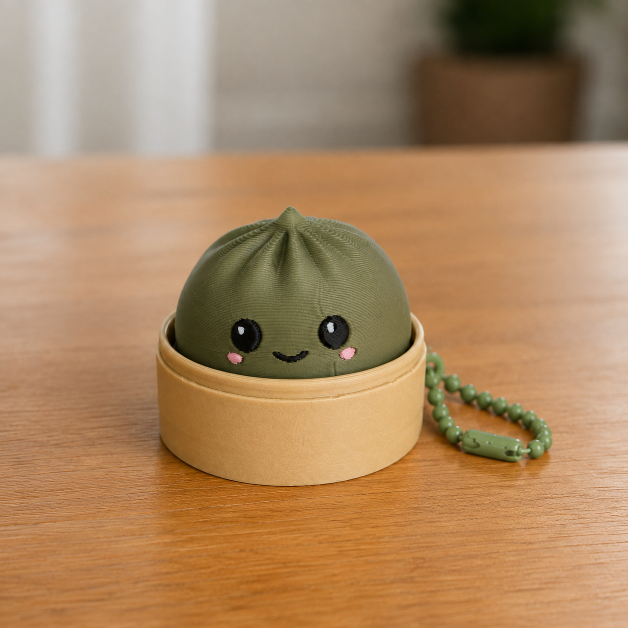 Dark Green dumpling fidget clicker keychain in its bamboo steamer basket, with ball chain