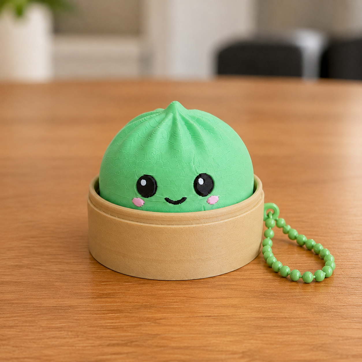 Grass Green dumpling fidget clicker keychain in its bamboo steamer basket, with ball chain