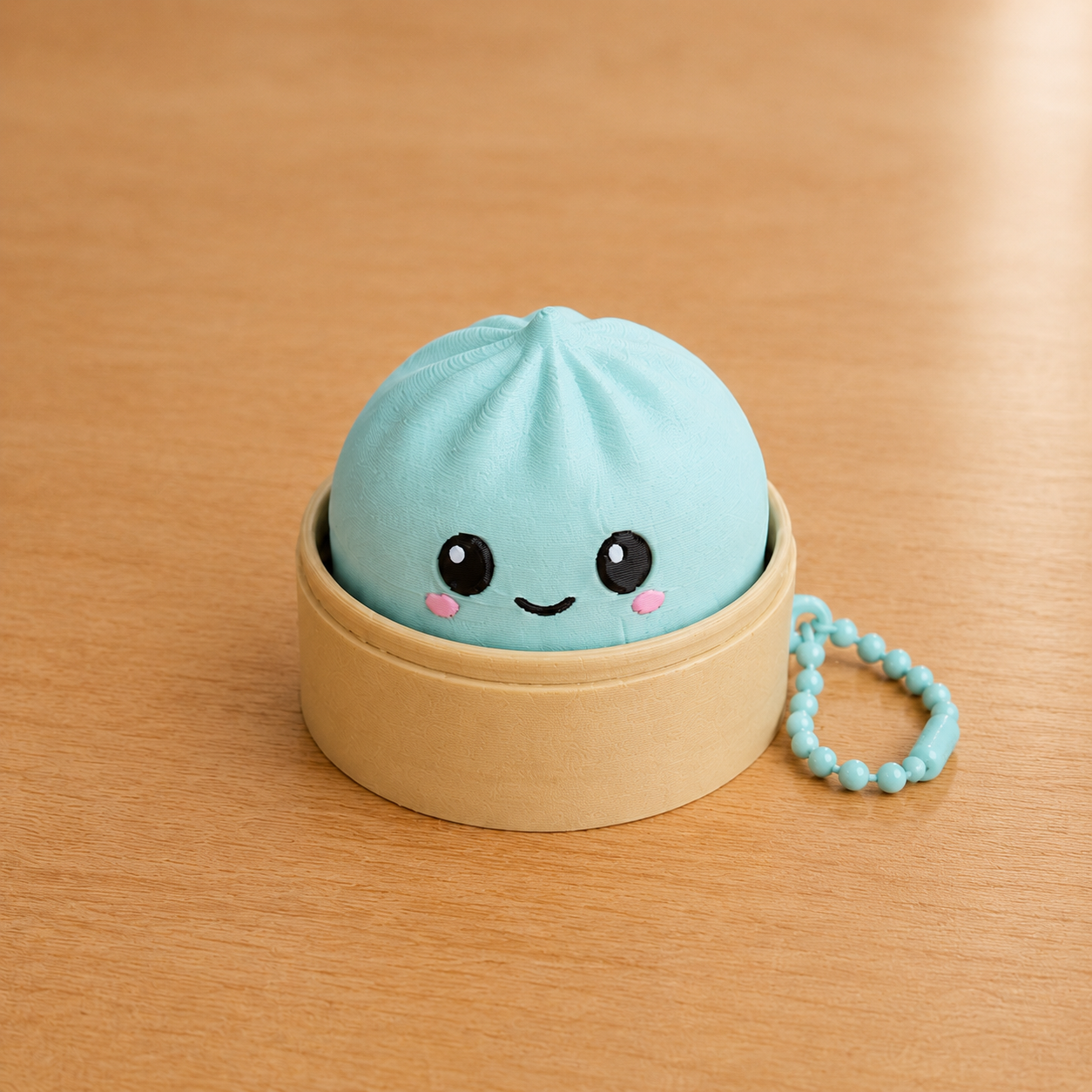 Ice Blue dumpling fidget clicker keychain in its bamboo steamer basket, with ball chain