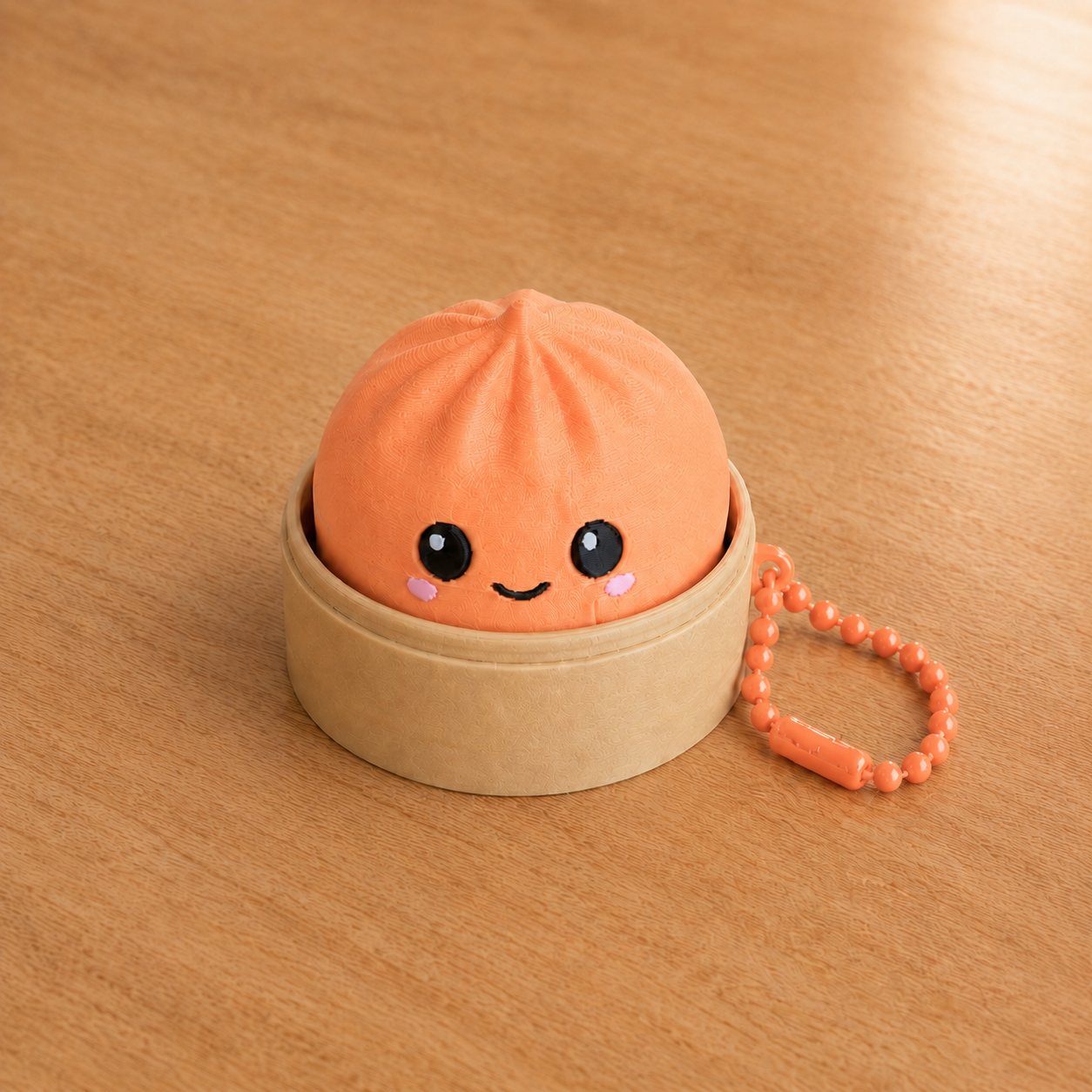 Mandarin Orange dumpling fidget clicker keychain in its bamboo steamer basket, with ball chain