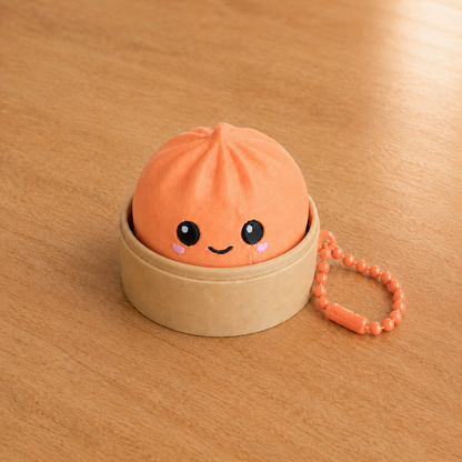 Mandarin Orange dumpling fidget clicker keychain in its bamboo steamer basket, with ball chain