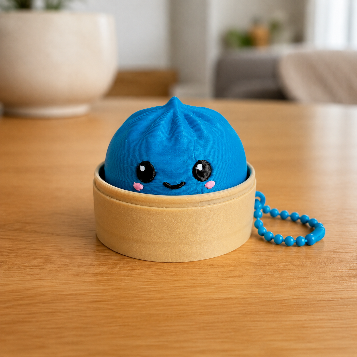 Marine Blue dumpling fidget clicker keychain in its bamboo steamer basket, with ball chain