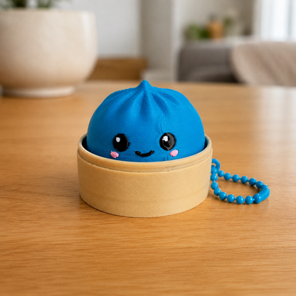 Marine Blue dumpling fidget clicker keychain in its bamboo steamer basket, with ball chain
