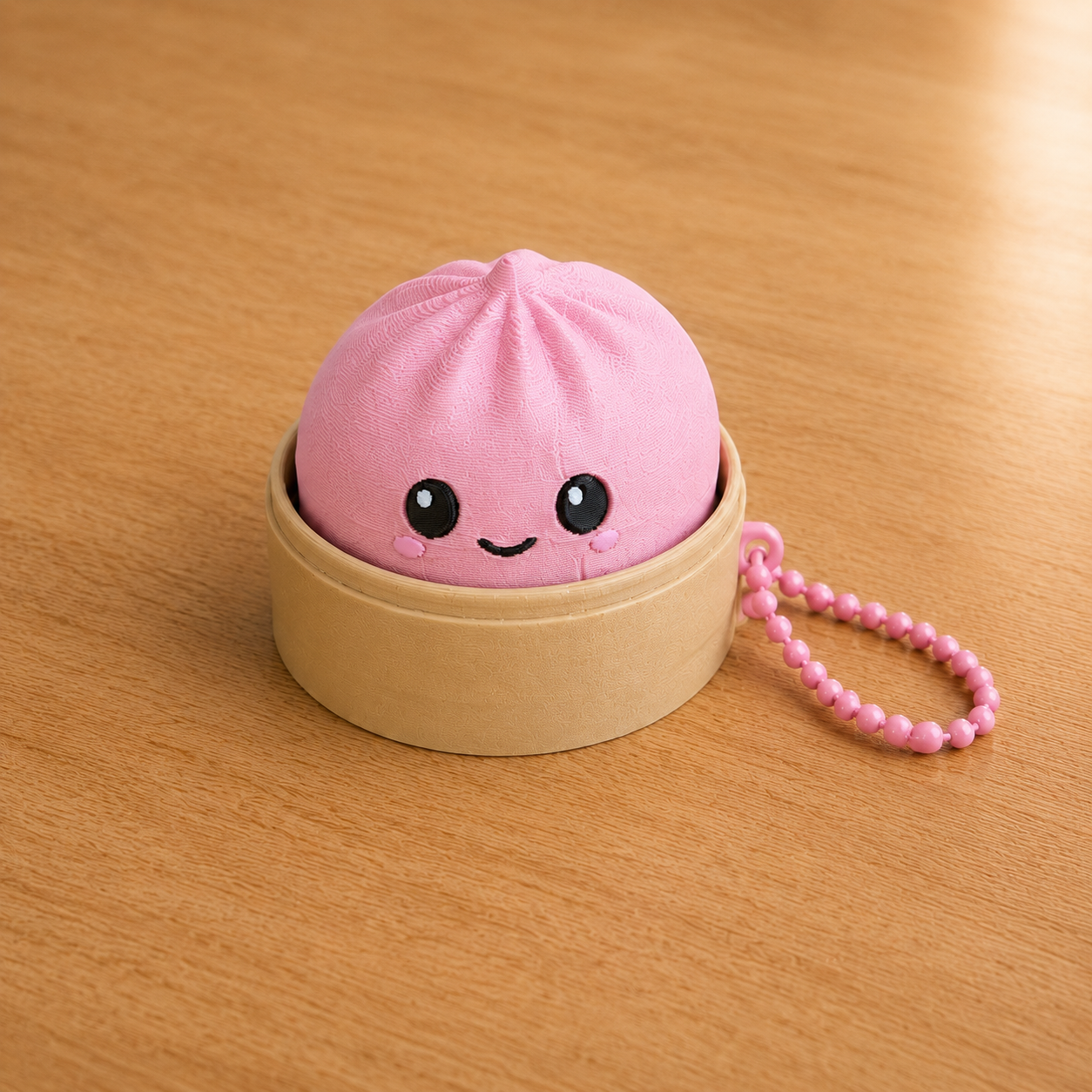 Sakura Pink dumpling fidget clicker keychain in its bamboo steamer basket, with ball chain