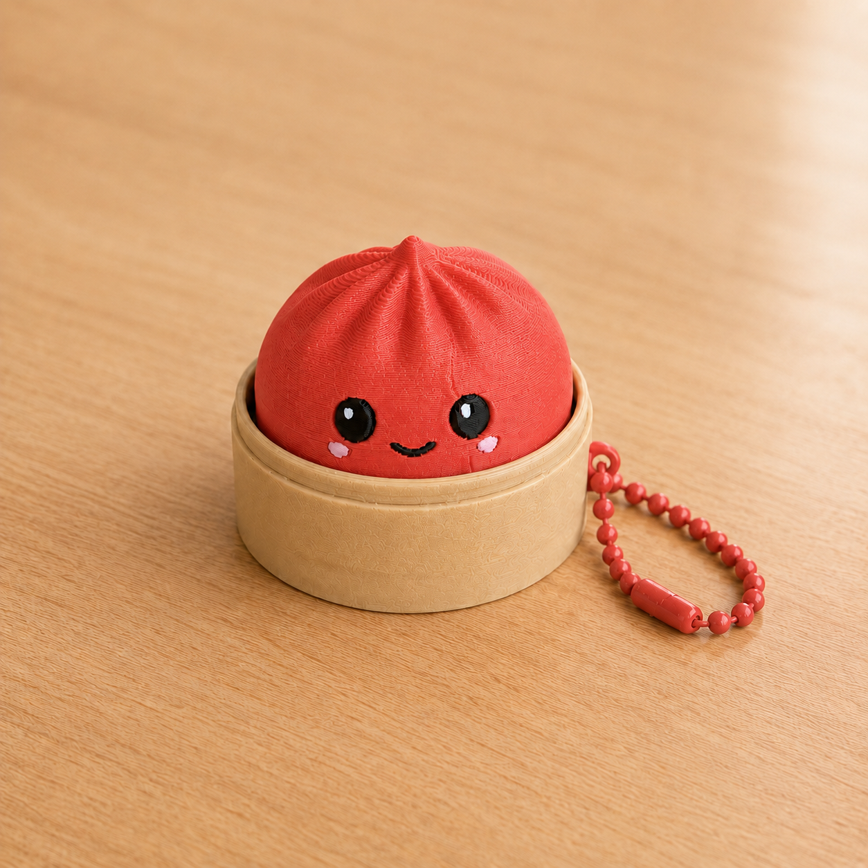 Scarlet Red dumpling fidget clicker keychain in its bamboo steamer basket, with ball chain