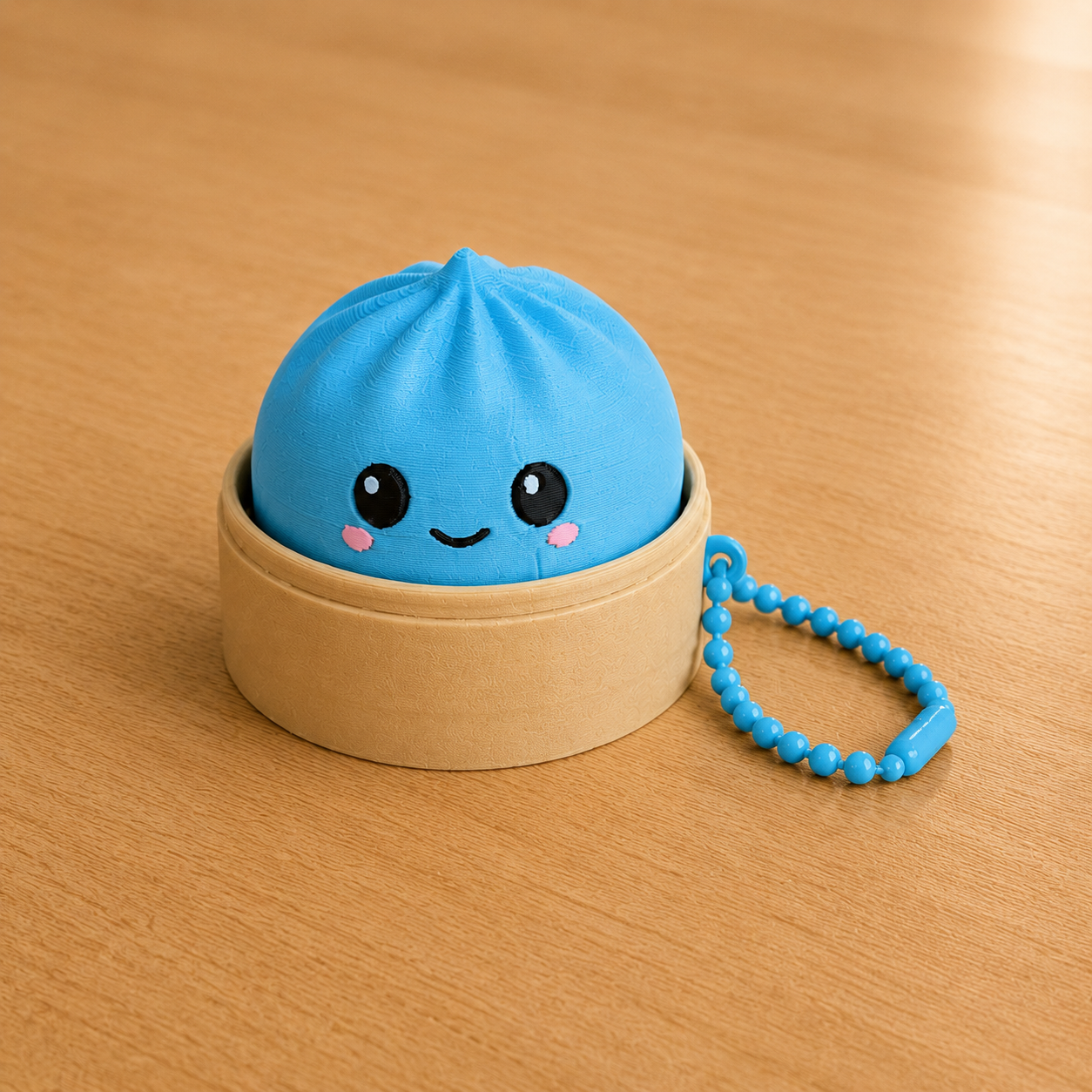 Sky Blue dumpling fidget clicker keychain in its bamboo steamer basket, with ball chain