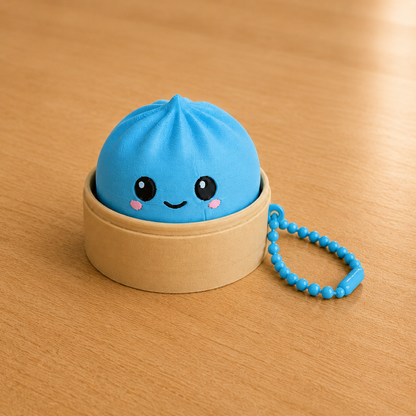 Sky Blue dumpling fidget clicker keychain in its bamboo steamer basket, with ball chain