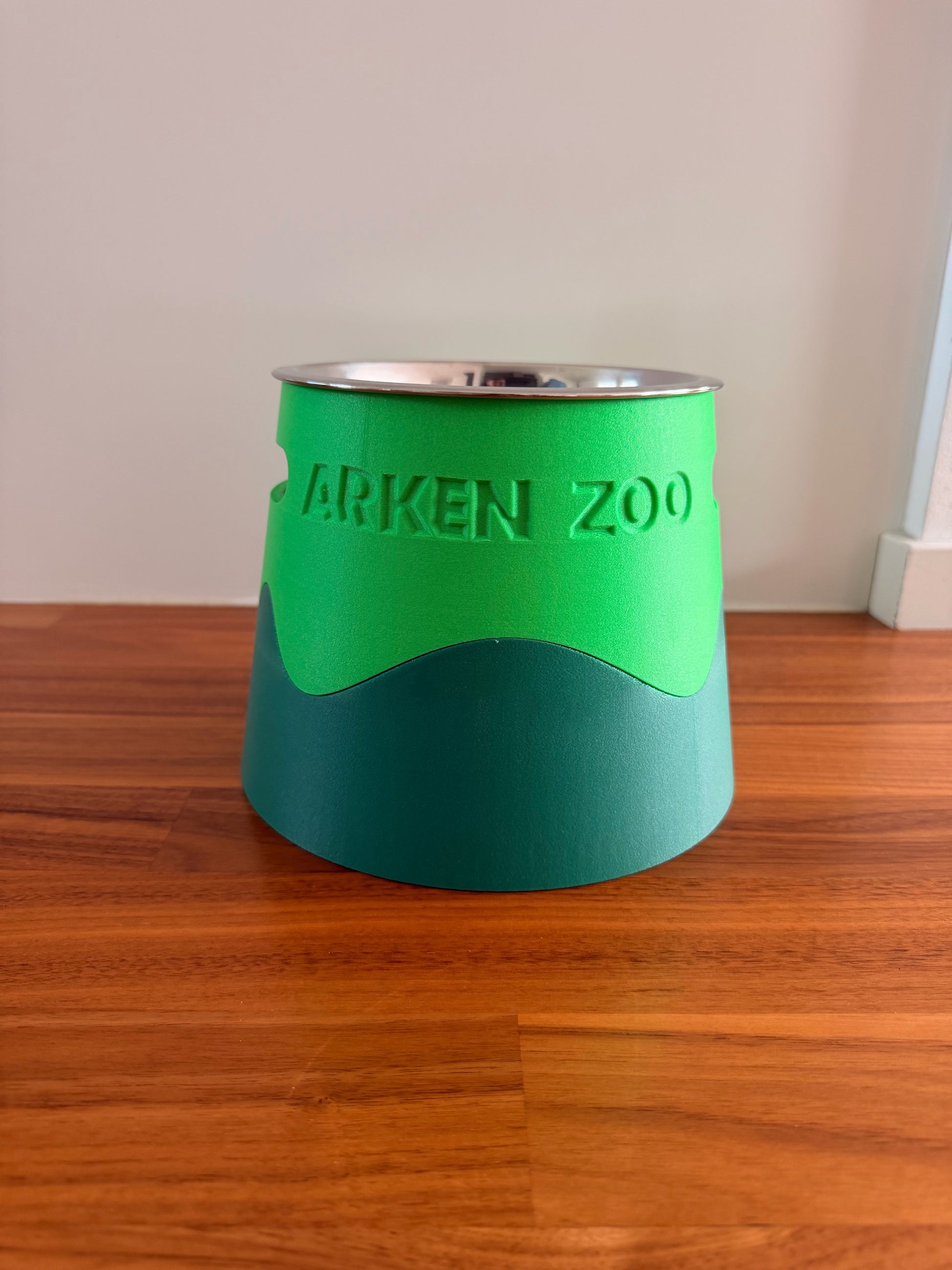 Assembled bowl stand in two shades of green with a stainless steel bowl resting in the opening