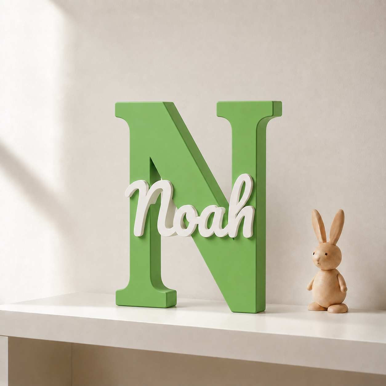 Green 3D printed letter N name sign with the name Noah in white script, standing on a shelf