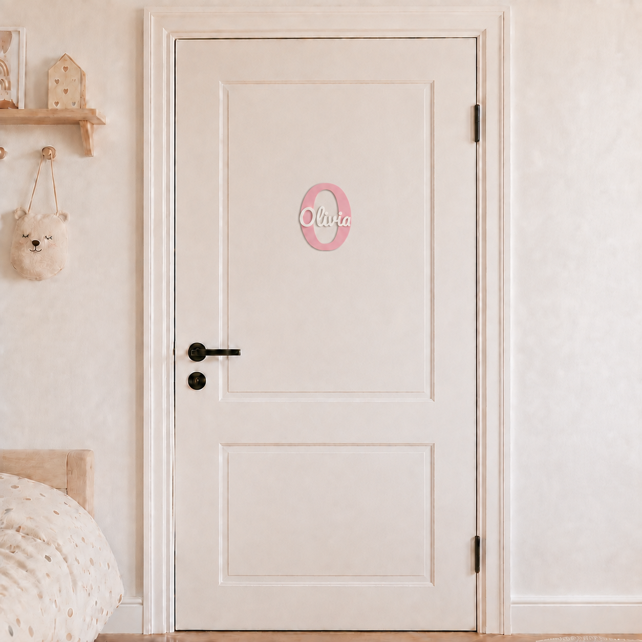 Pink 3D printed letter O name sign with the name Olivia in white script, mounted on a child's bedroom door