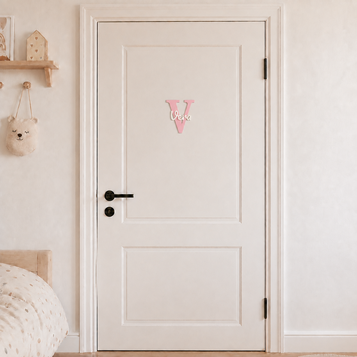 Pink 3D printed letter V name sign with the name Vera in white script, mounted on a child's bedroom door