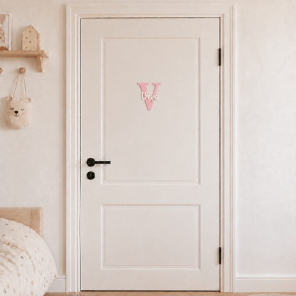 Pink 3D printed letter V name sign with the name Vera in white script, mounted on a child's bedroom door