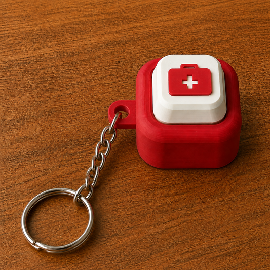 Red and white Hospital Clicker with a medical bag design, raised white button, side loop, metal chain and split ring on a wooden surface.