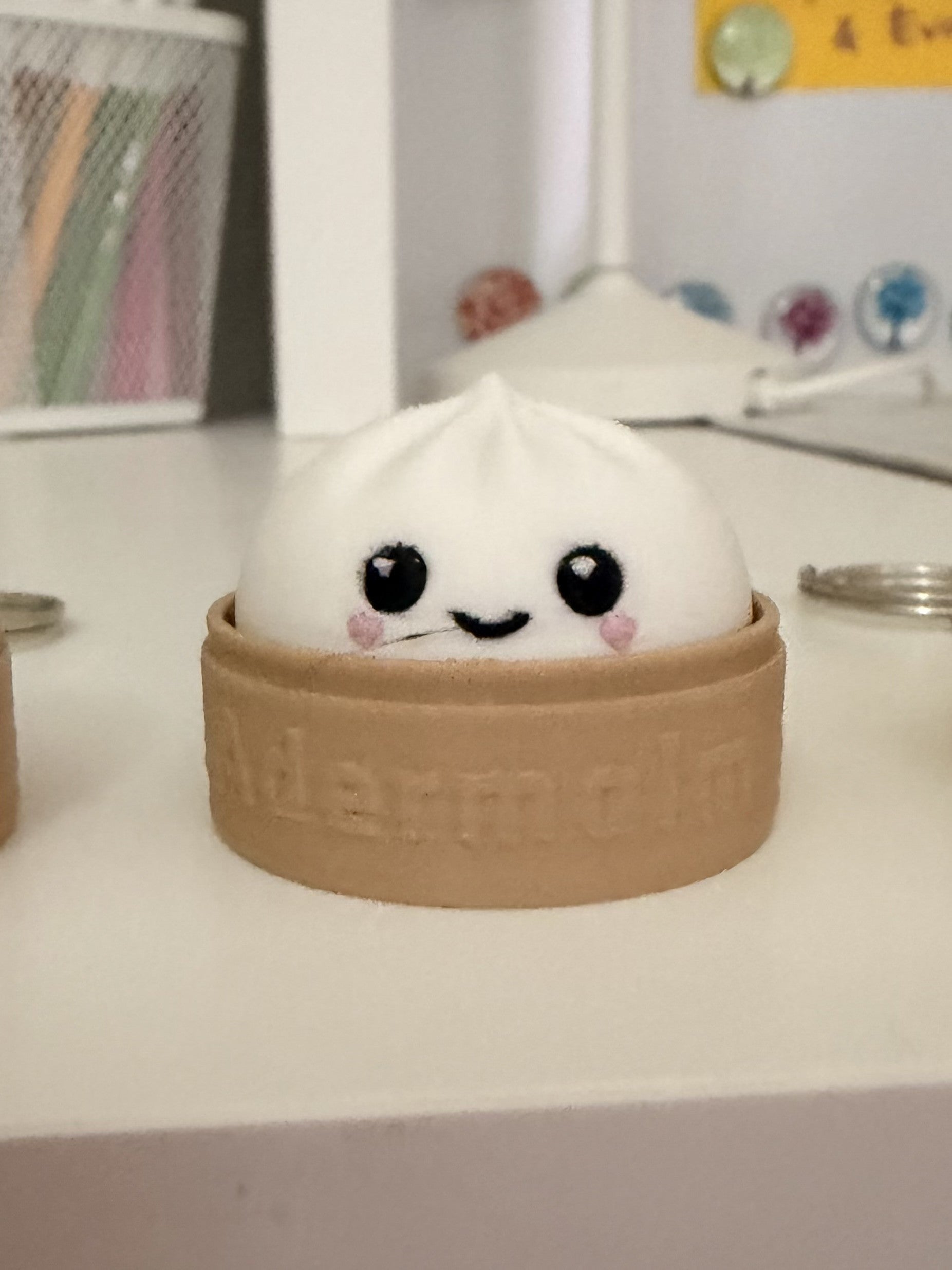 White dumpling fidget clicker keychain with kawaii face in steamer basket, close-up