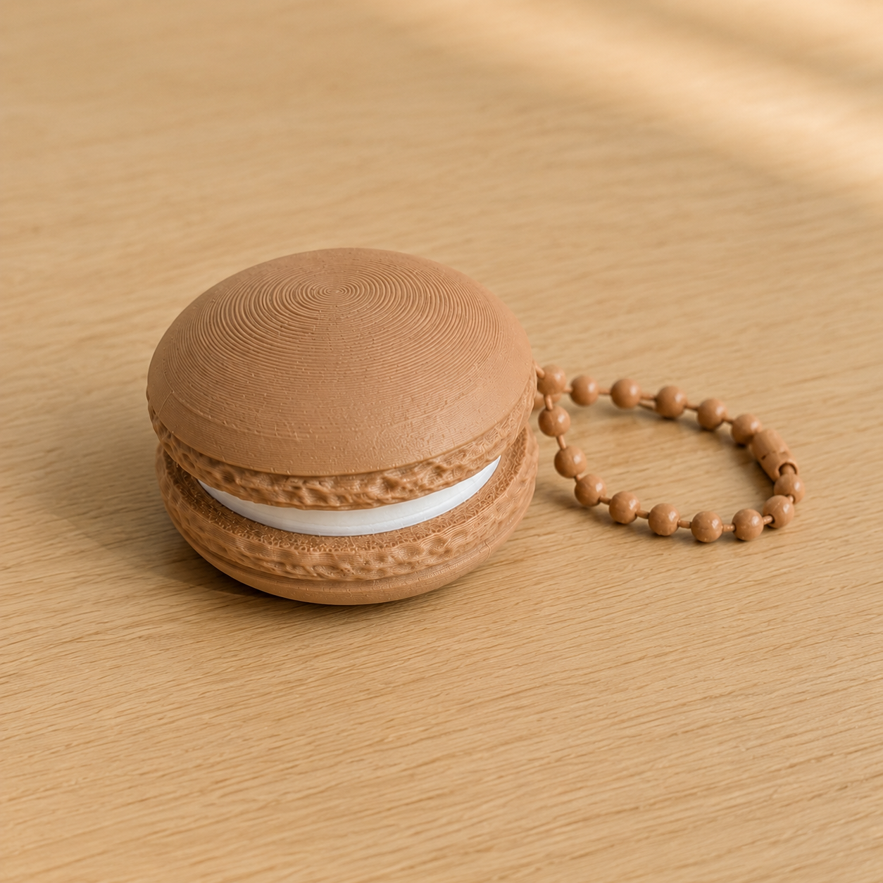 Caramel 3D printed macaron fidget clicker keychain with white filling and matching ball chain