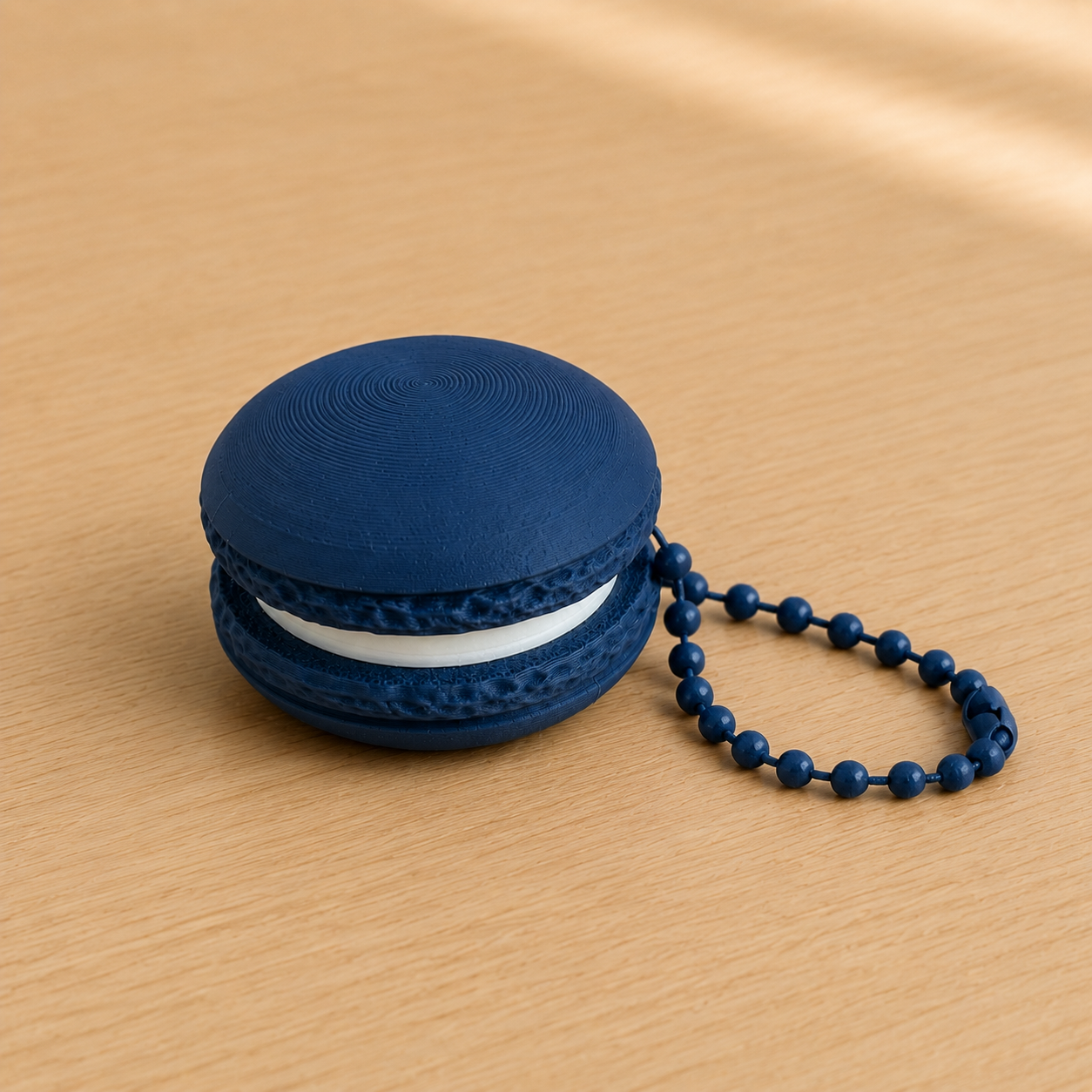 Dark Blue 3D printed macaron fidget clicker keychain with white filling and matching ball chain