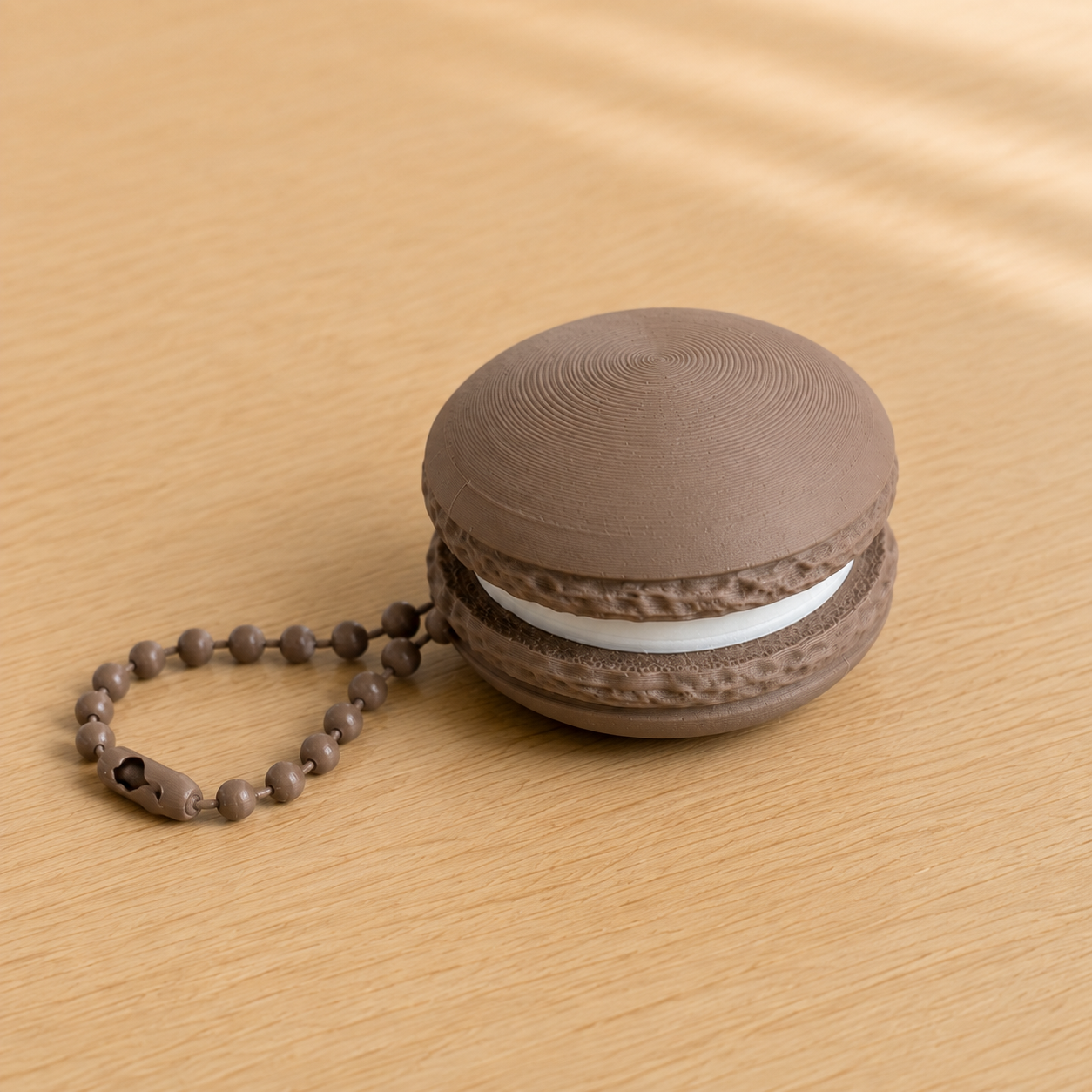 Dark Brown 3D printed macaron fidget clicker keychain with white filling and matching ball chain