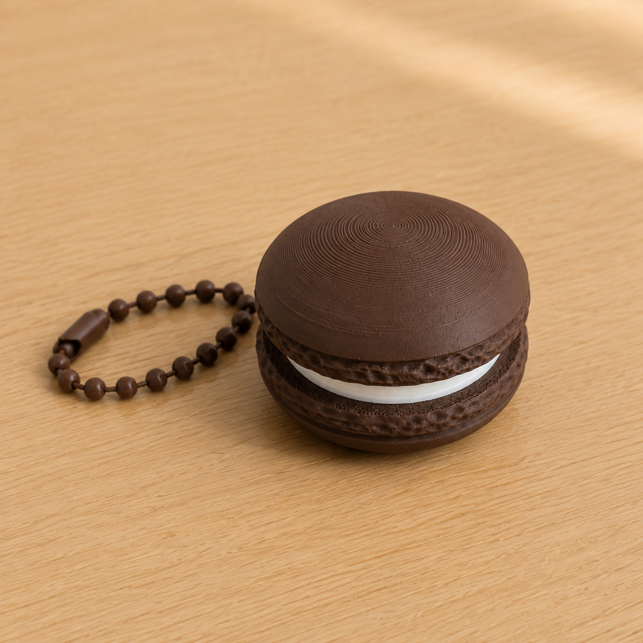 Dark Chocolate 3D printed macaron fidget clicker keychain with white filling and matching ball chain