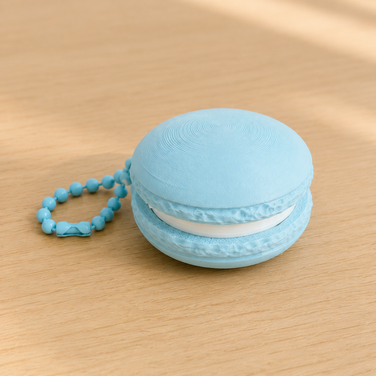 Ice Blue 3D printed macaron fidget clicker keychain with white filling and matching ball chain