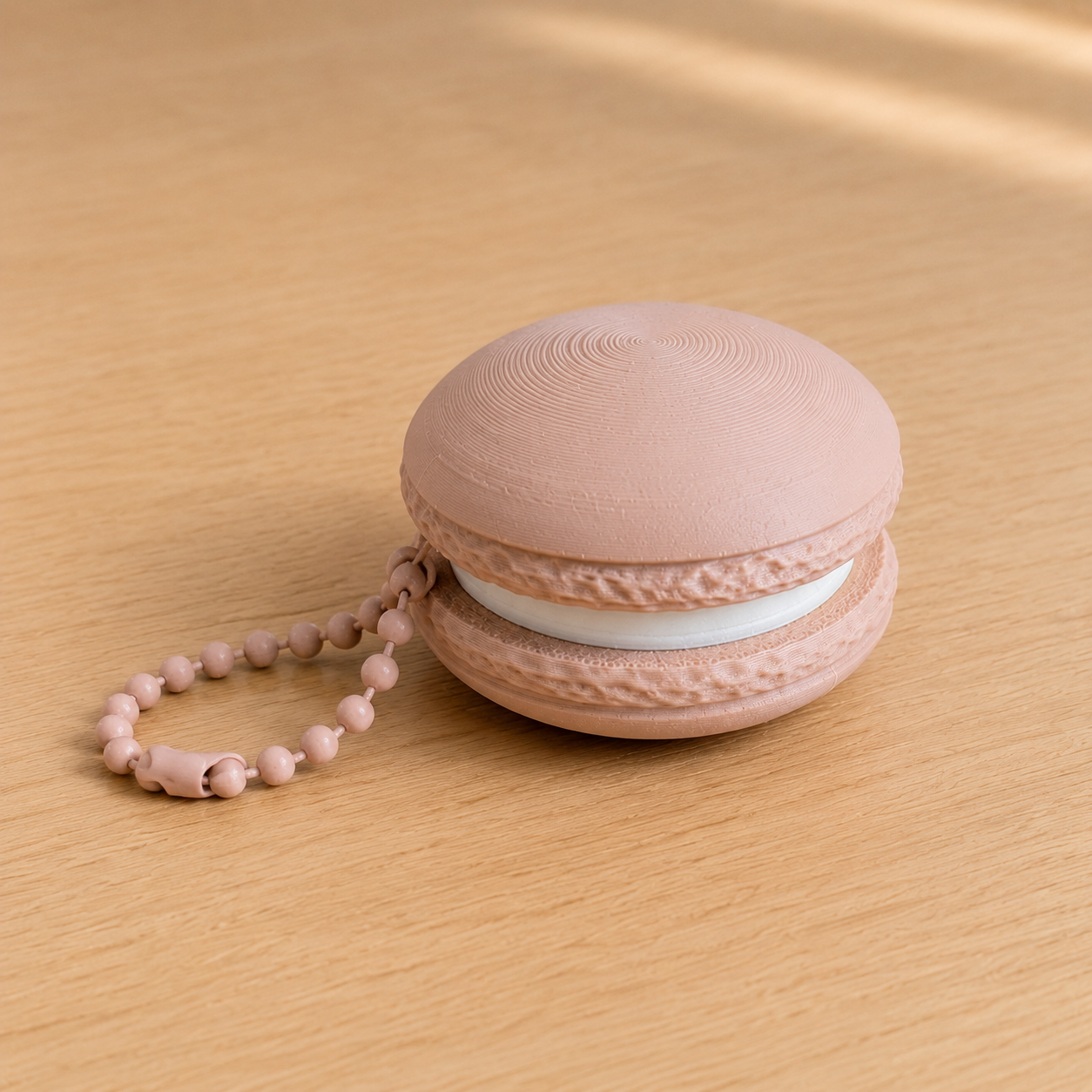 Latte Brown 3D printed macaron fidget clicker keychain with white filling and matching ball chain