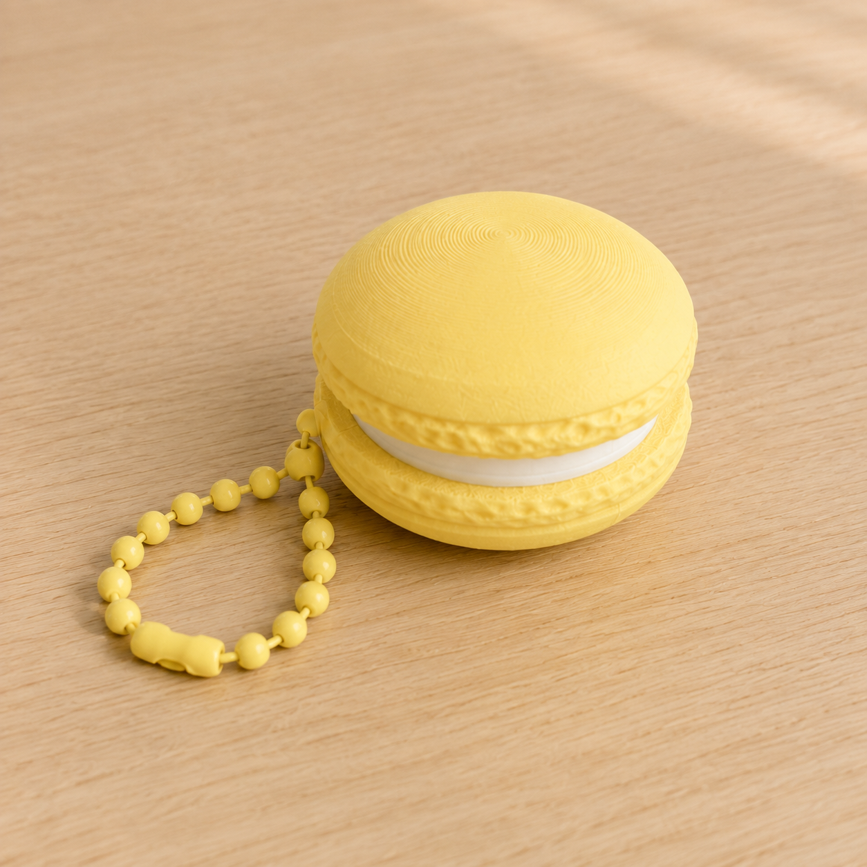 Lemon Yellow 3D printed macaron fidget clicker keychain with white filling and matching ball chain