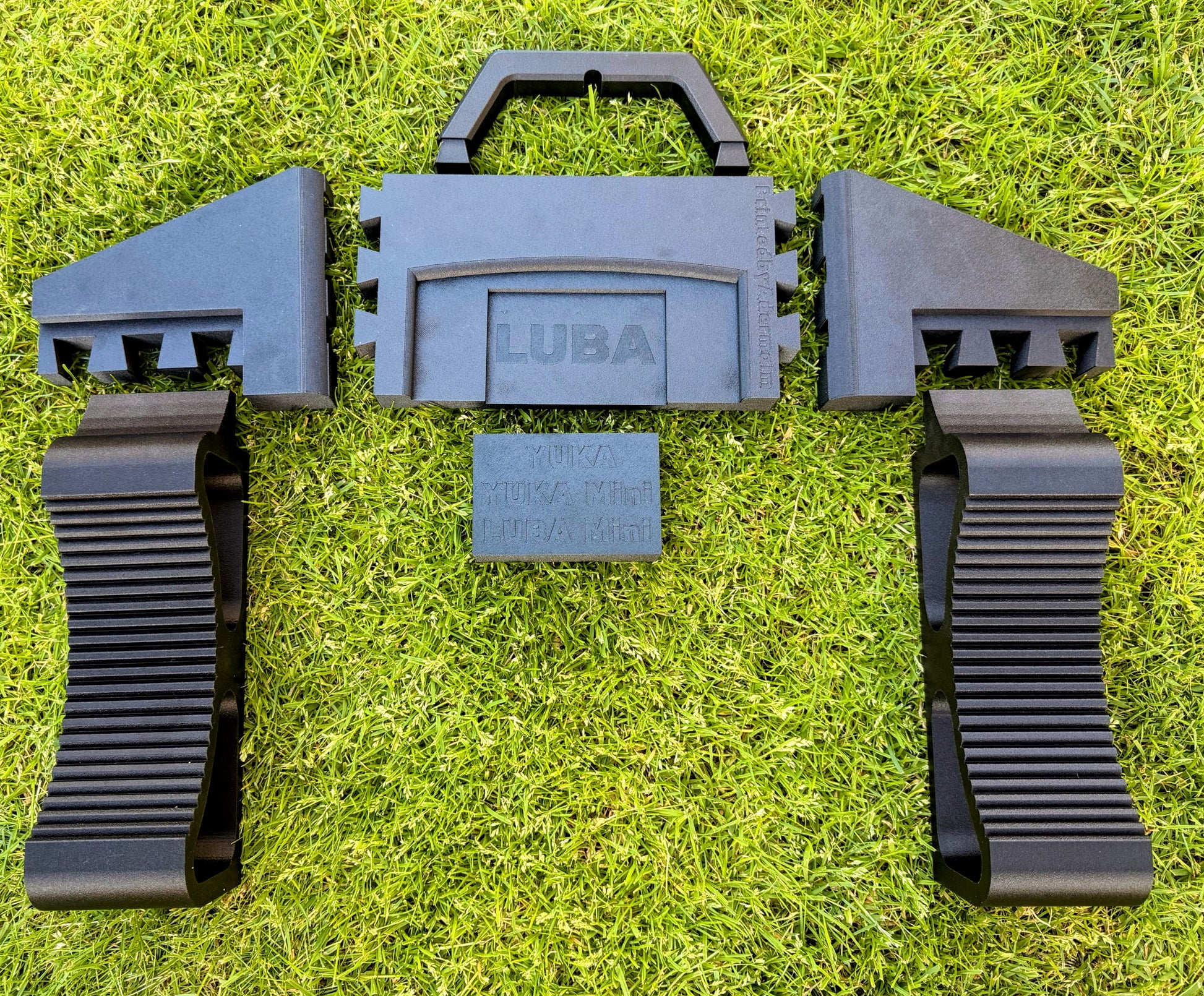 Mammotion service stand shown disassembled as a flat-pack with all seven parts: two ribbed wheel cradles, two support wings, base section, carry handle and spacer