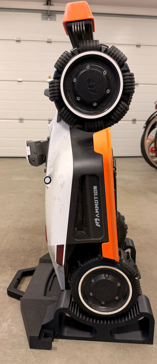 Mammotion Luba robot mower tilted up and secured on the service stand for blade changes and underside cleaning