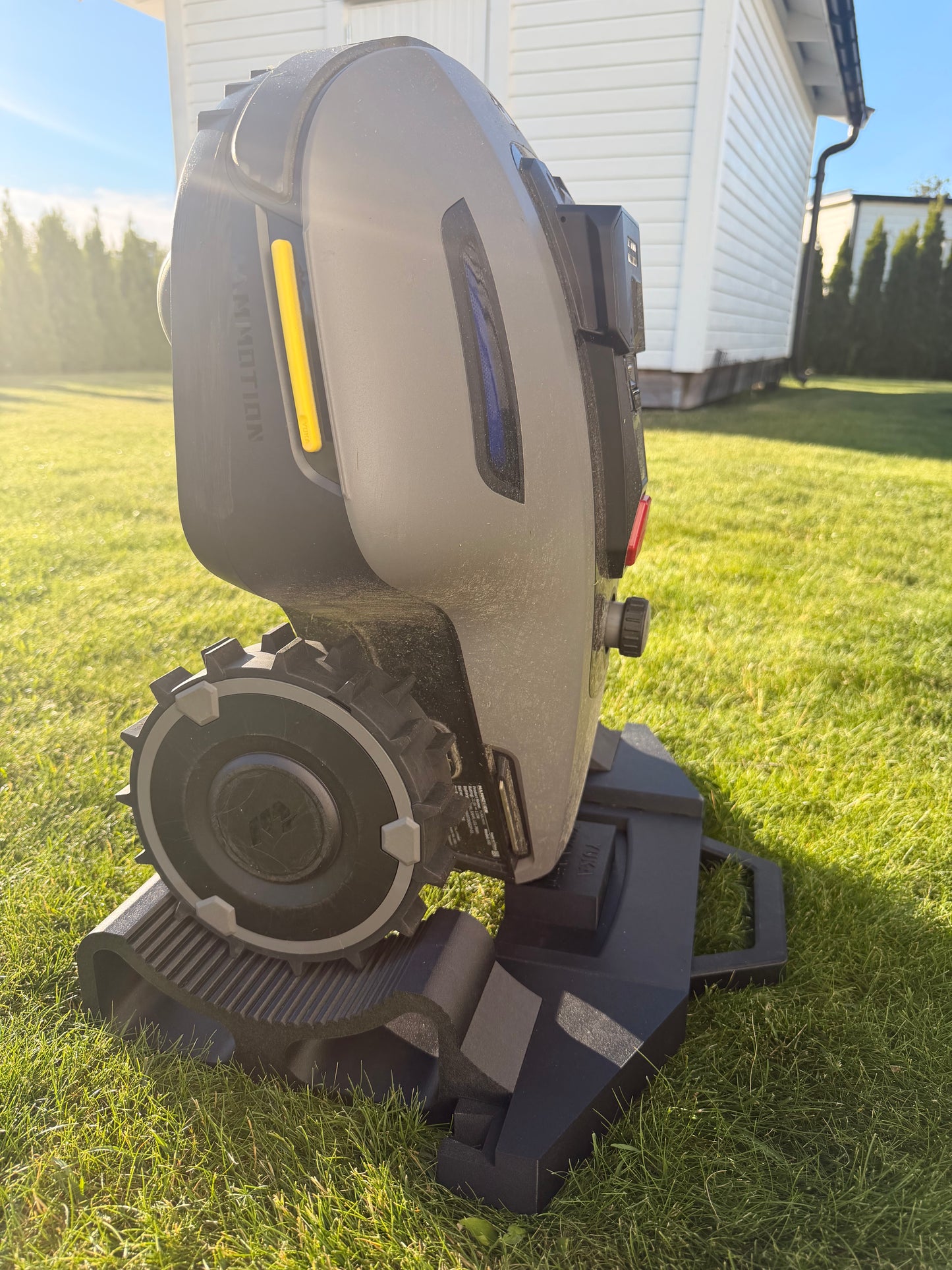 Mammotion Yuka Mini robot mower held upright on the service and maintenance stand
