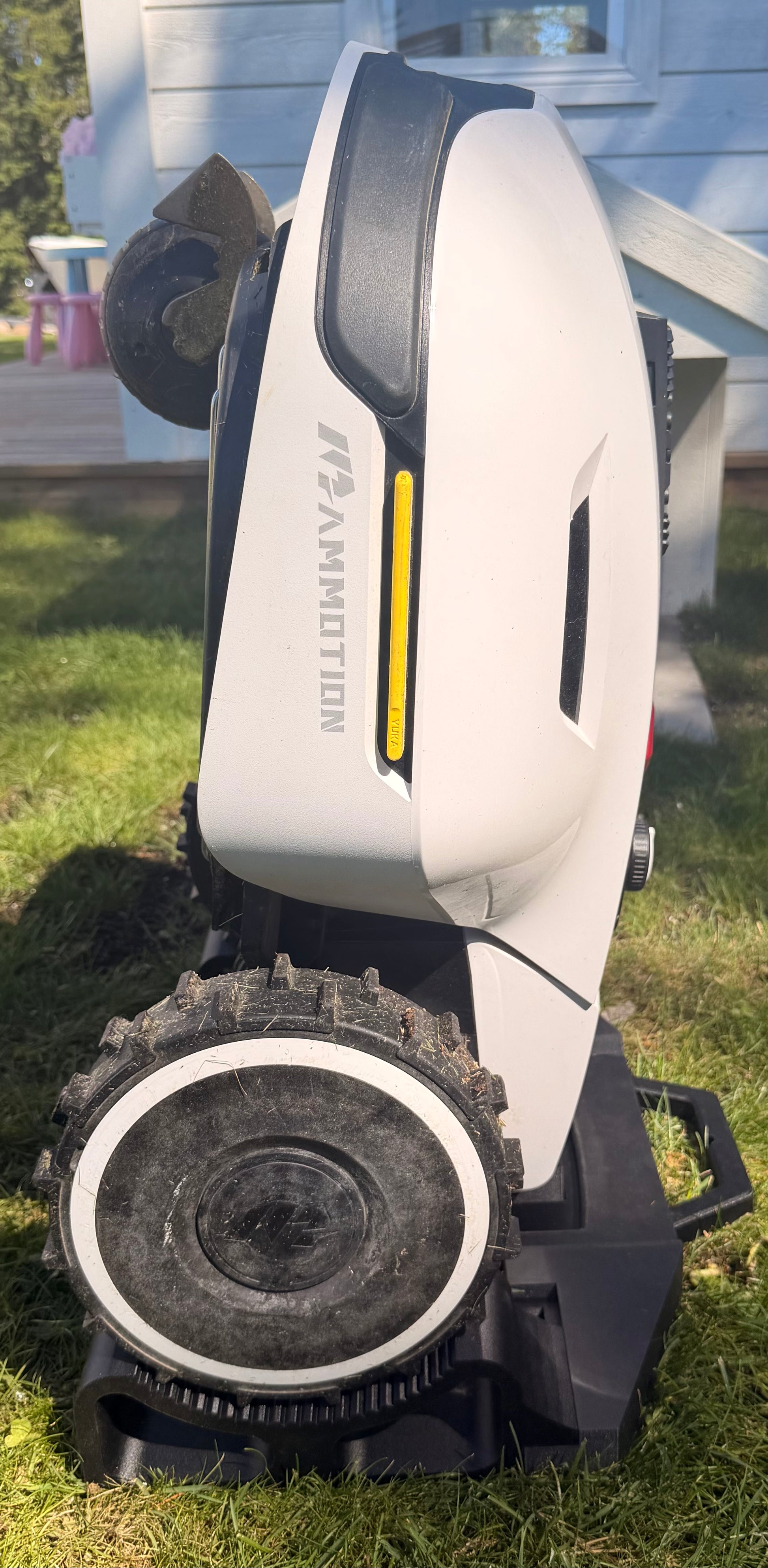 Mammotion Yuka robot mower held upright on the service and maintenance stand
