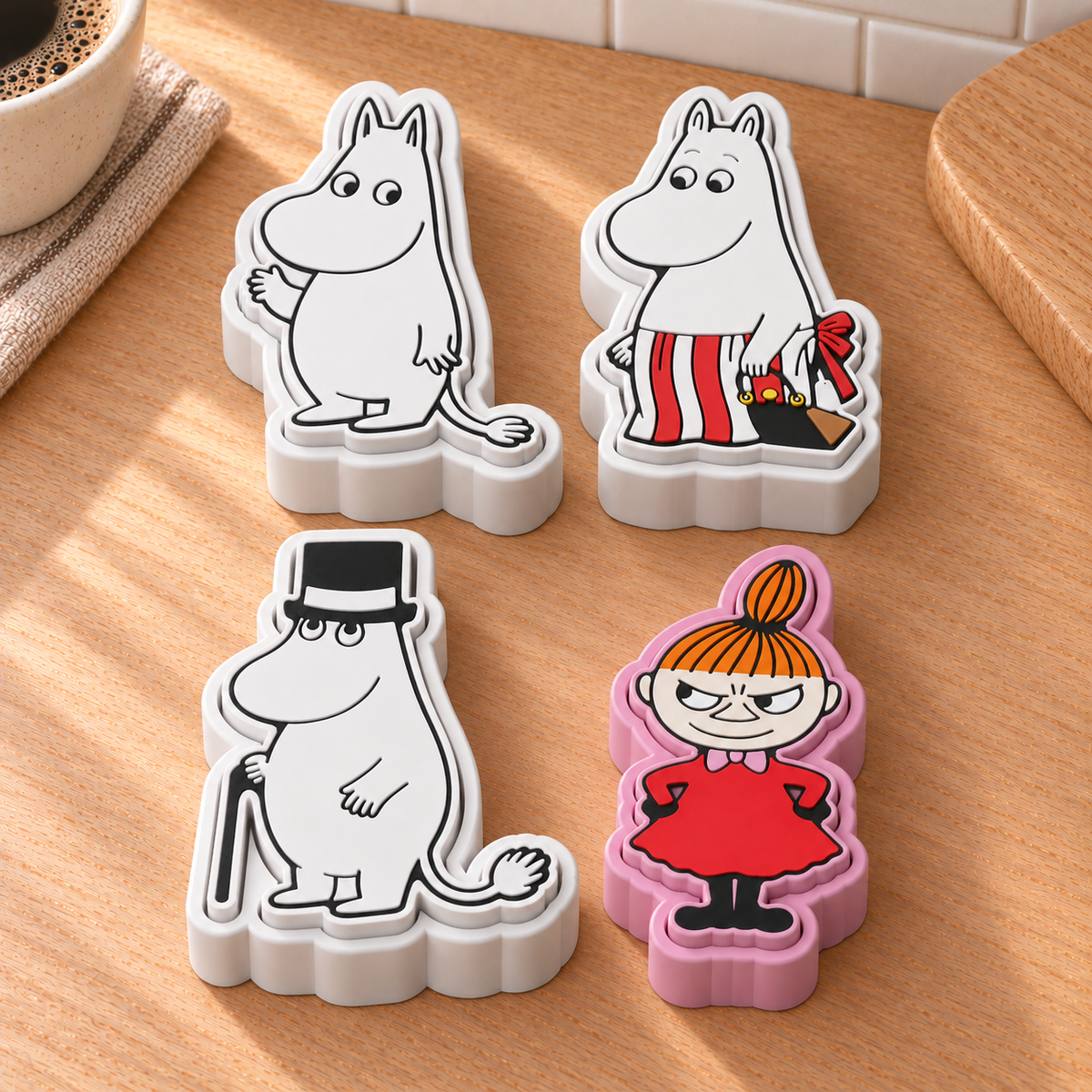 Moomintroll, Moominmamma, Moominpappa and Little My fidget clickers together on a Scandinavian kitchen counter.