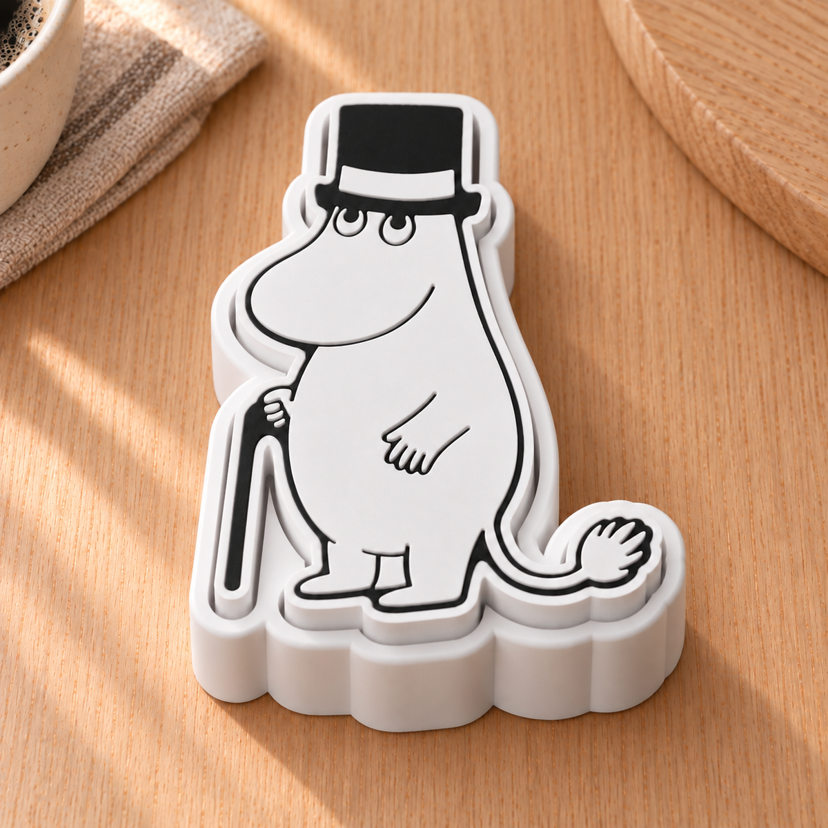 Moominpappa fidget clicker with black top hat and walking stick in a Scandinavian kitchen.