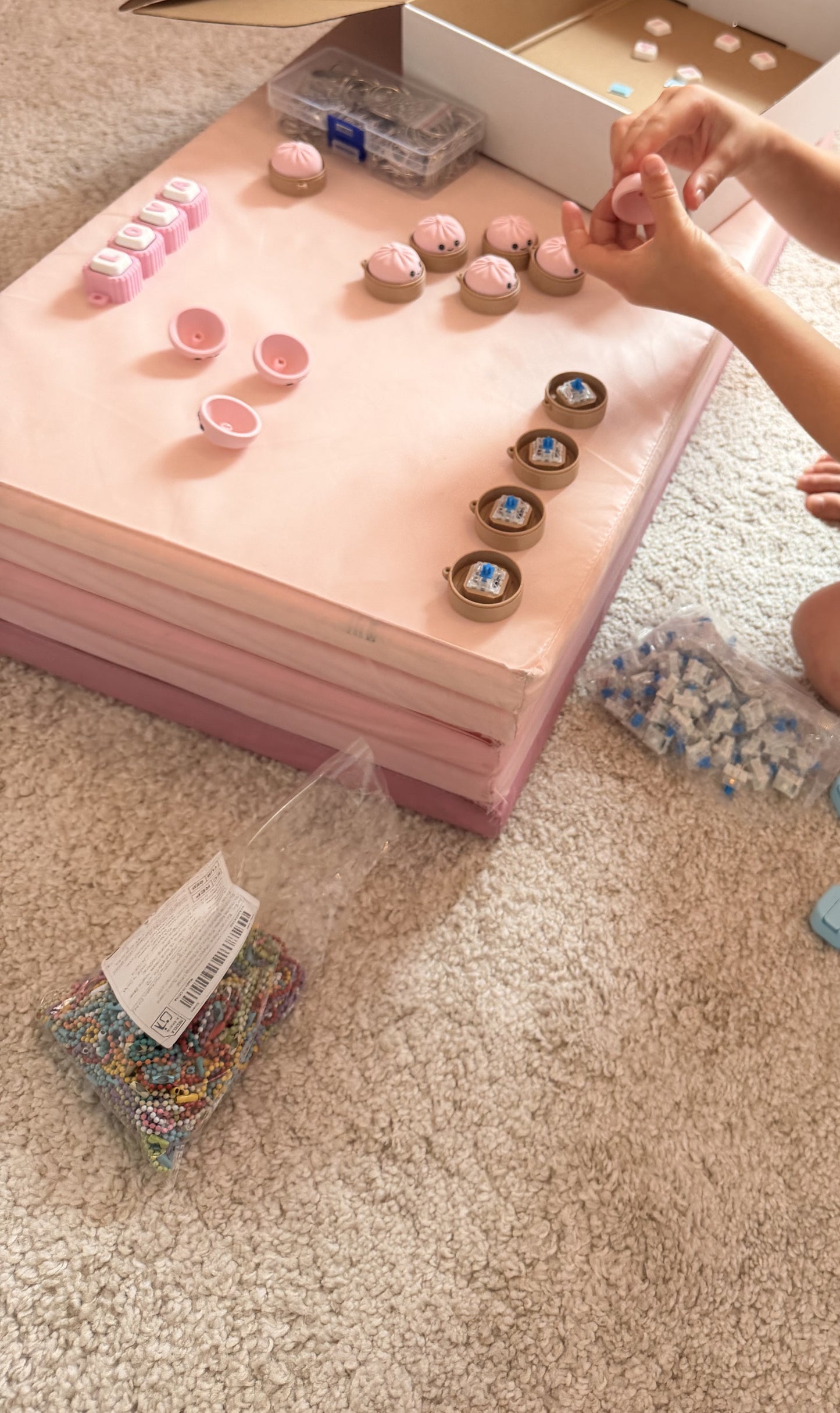 Lova assembling clicker keychains in the family workshop