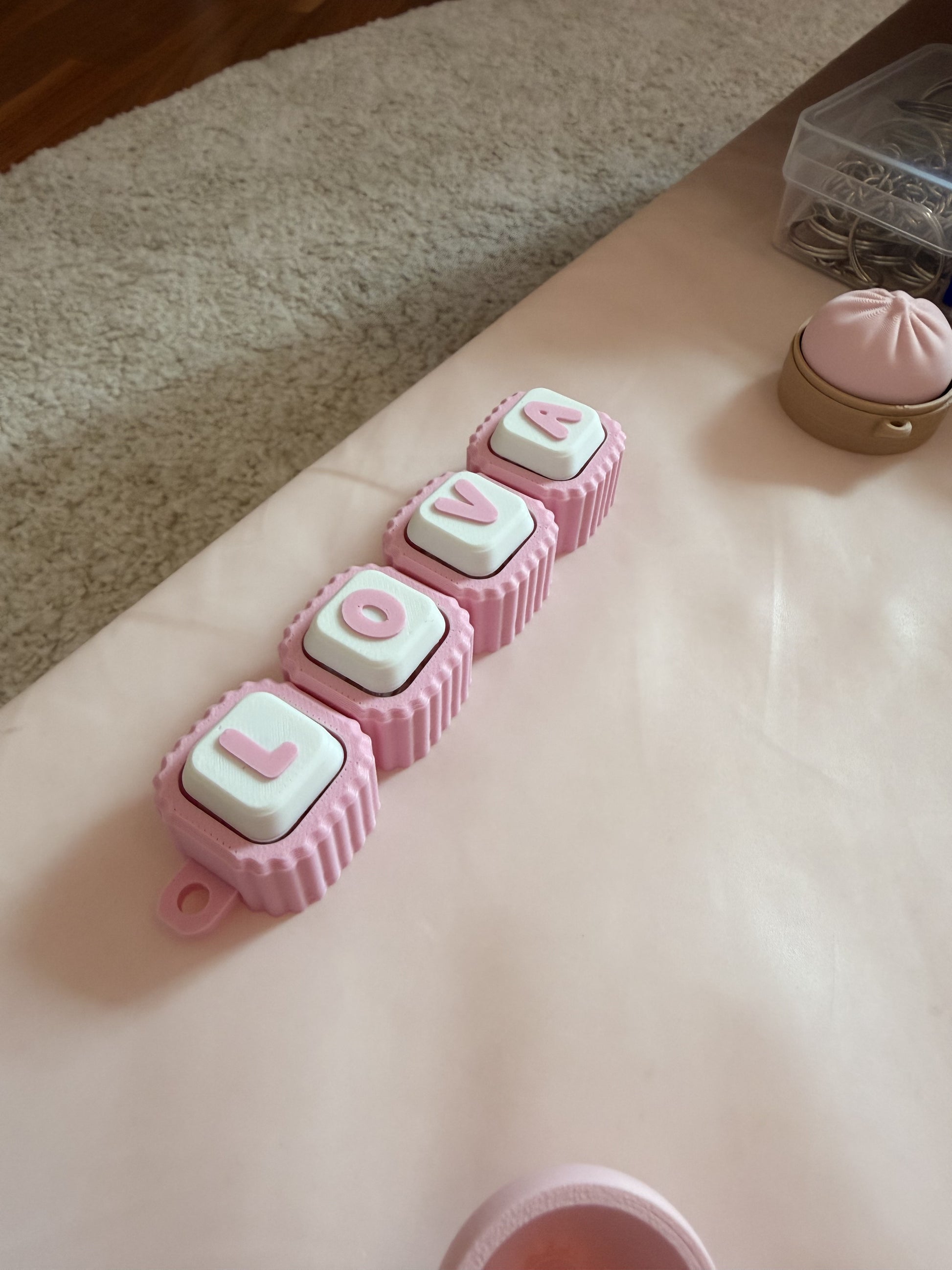 Pink and white modular name tag fidget clicker, flat lay