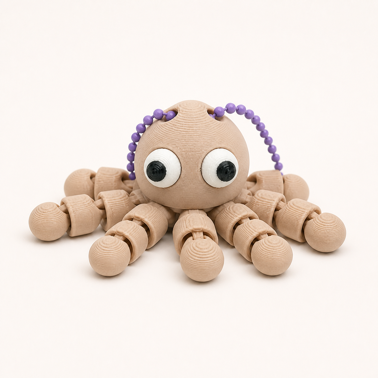Latte Brown articulated octopus flexi keychain with white eyes, on a ball chain