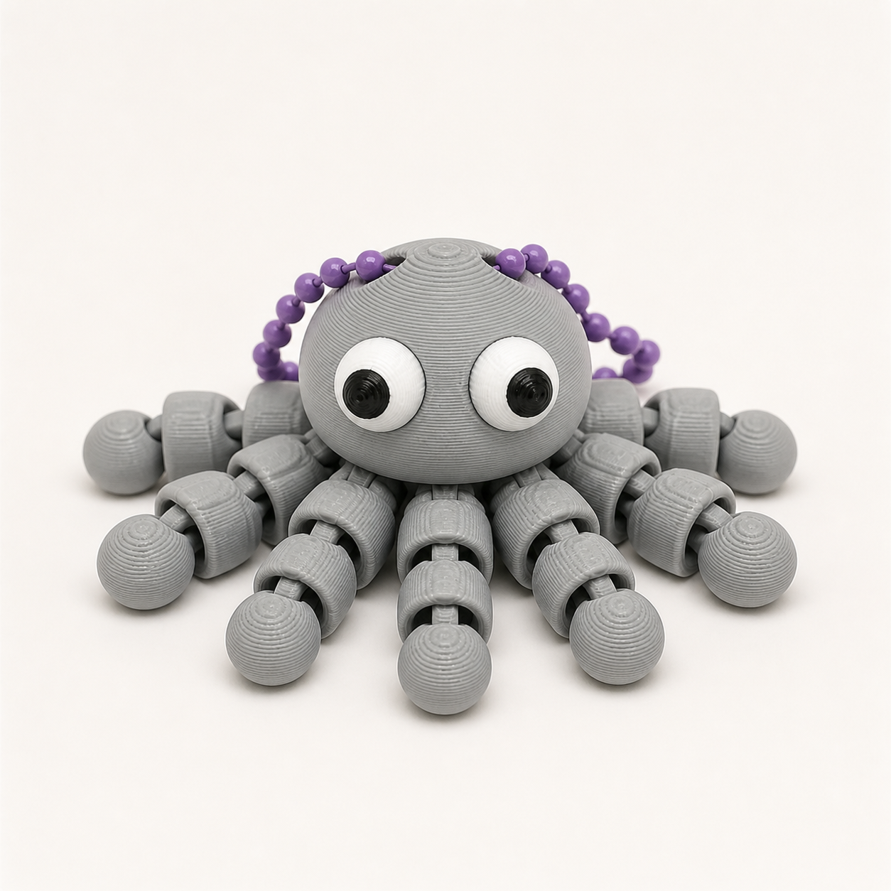 Ash Gray articulated octopus flexi keychain with white eyes, on a ball chain