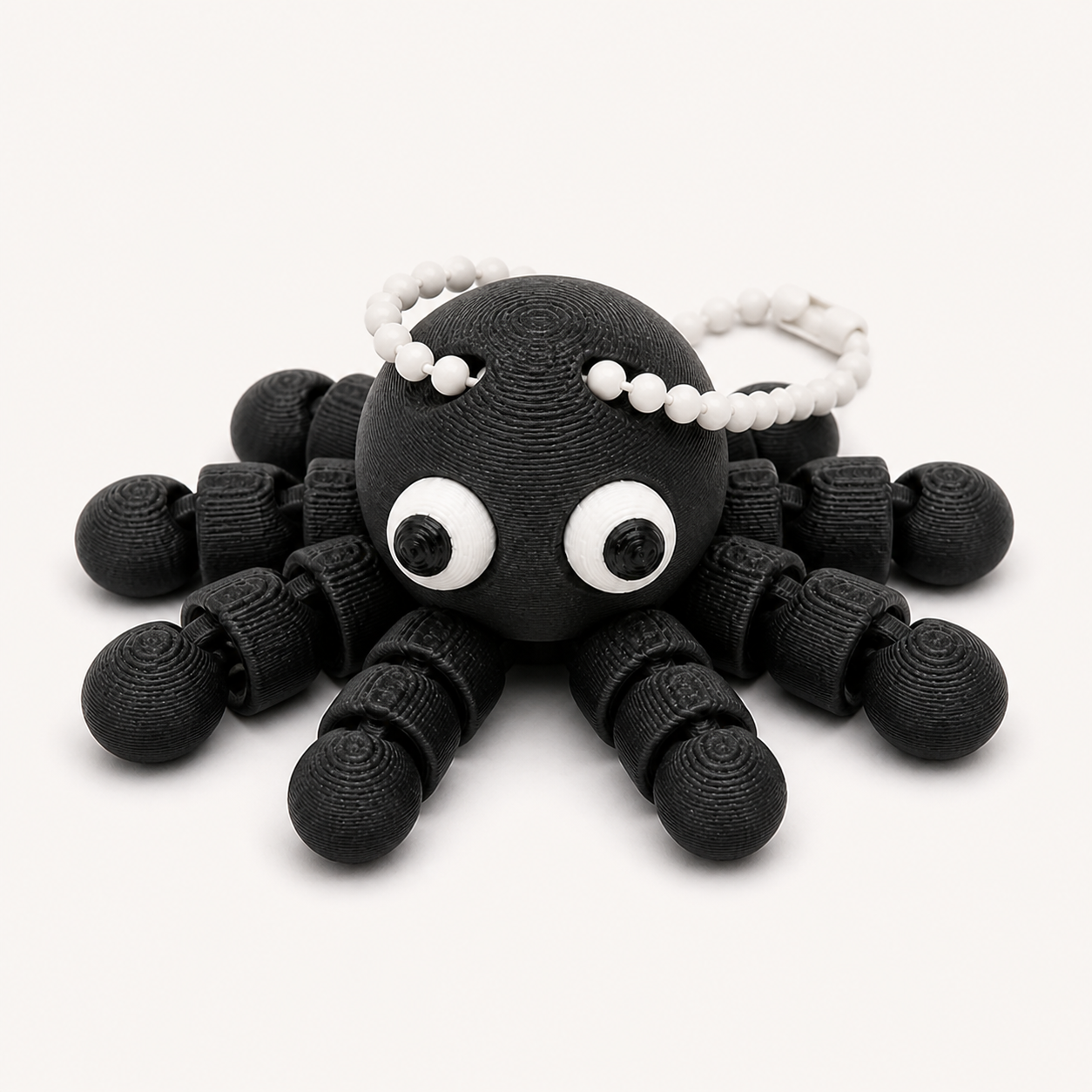 Charcoal articulated octopus flexi keychain with white eyes, on a ball chain